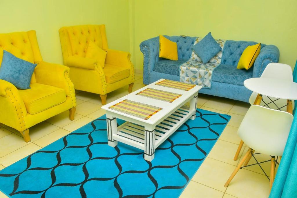 sala de estar con sillas amarillas y sofá azul en The O,S Homestay, en Chuka