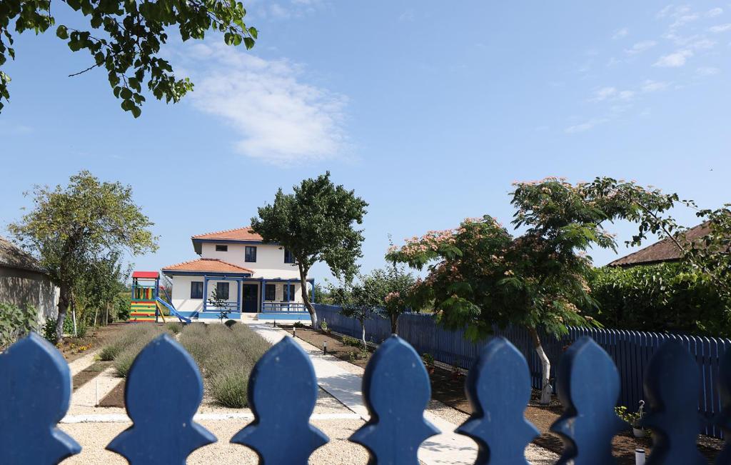 a blue fence with a house in the background at PRIVET in Jurilovca