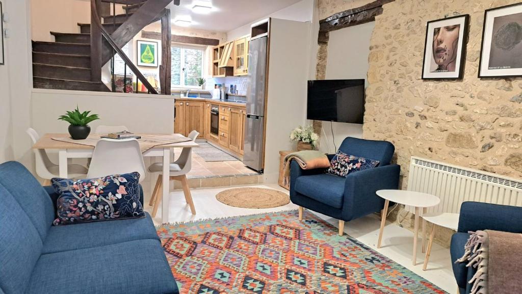 een woonkamer met blauwe stoelen en een tafel bij In the heart of the village - Charming & Authentic in Monpazier