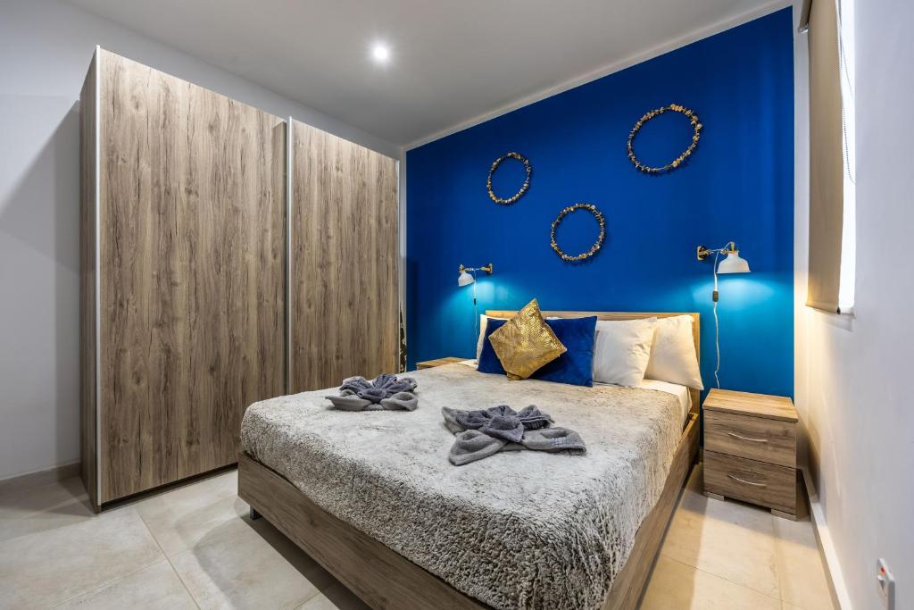 a bedroom with a blue accent wall and a bed at Ta Cetta Apartment 5 min walk from St Julians in San Ġwann