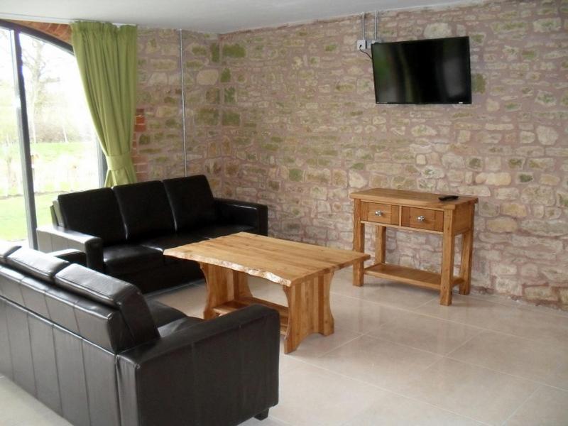 a living room with a couch and a coffee table at Swallows Swoop at Tove Valley Cottages in Towcester