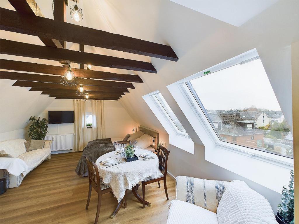 een woonkamer met een tafel en een aantal ramen bij Apartment in Leverkusen Waldsiedlung in Leverkusen