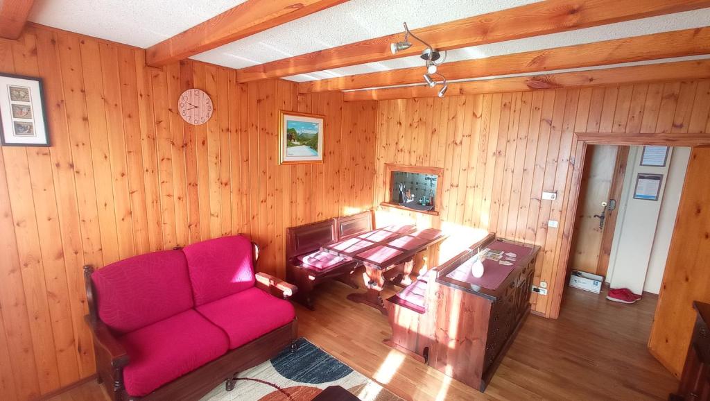 a living room with a red couch and a table at Appartamento Oasi Zegna in Bielmonte