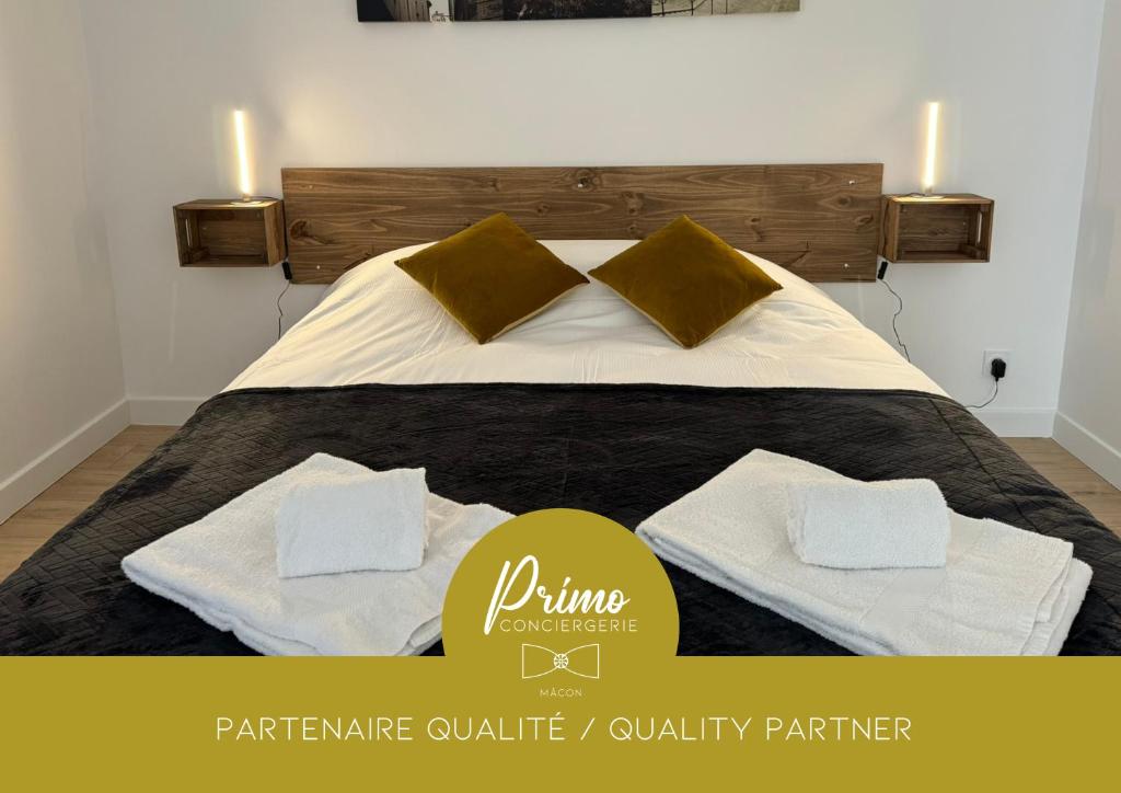 une chambre avec un lit avec deux serviettes dessus dans l'établissement Appart'hotel Le clos des voyageurs - BY PRIMO C0NCIERGERIE, à Sennecey-le-Grand