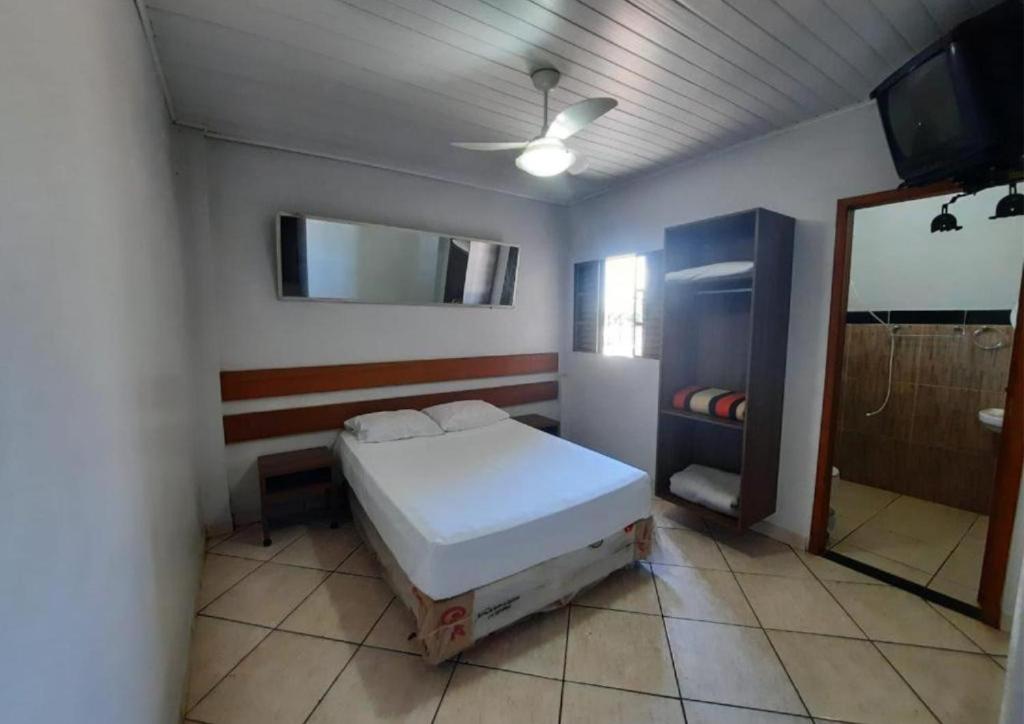 een slaapkamer met een bed en een spiegel aan de muur bij Hotel Presidente - By UP Hotel in Campo Mourão