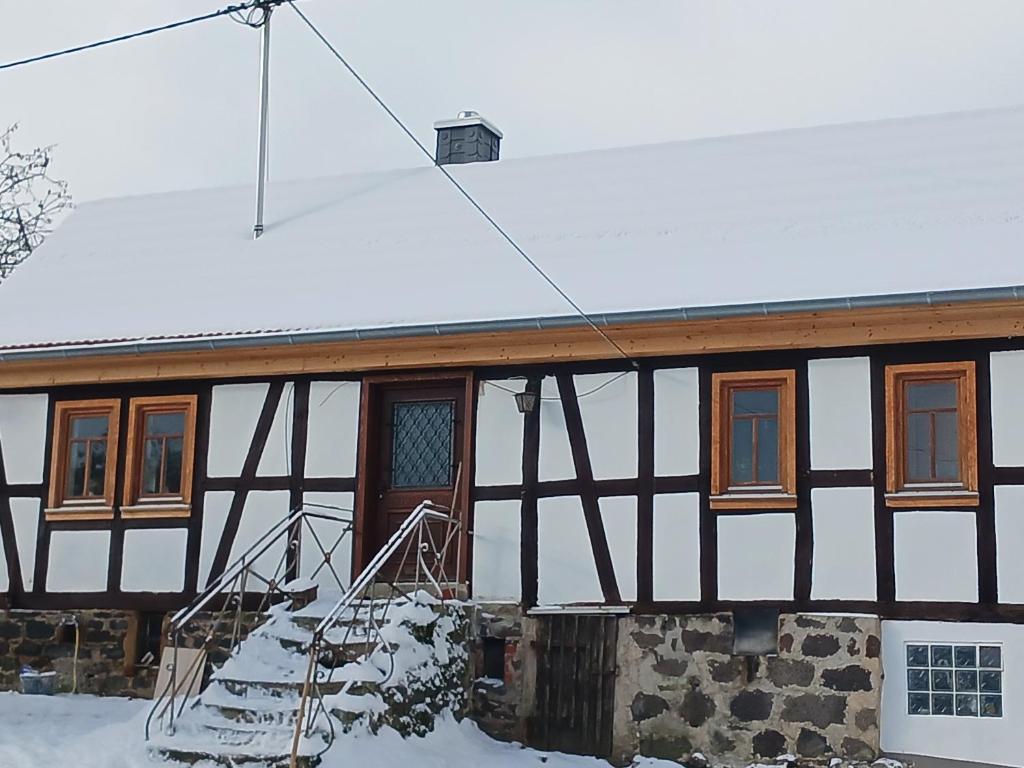una casa en blanco y negro con nieve en el techo en Alte Schule, en Grebenhain