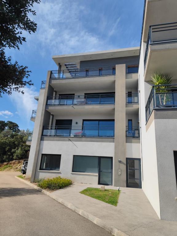 un immeuble d'appartements avec beaucoup de fenêtres dans l'établissement Bel appartement spacieux à Porto-Vecchio, 10min à pieds du centre ville, à Porto-Vecchio