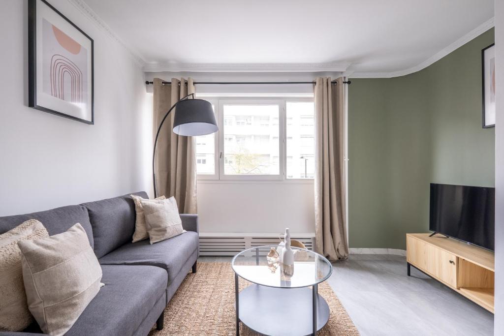 a living room with a couch and a table at Appartement Charmant à Levallois in Levallois-Perret