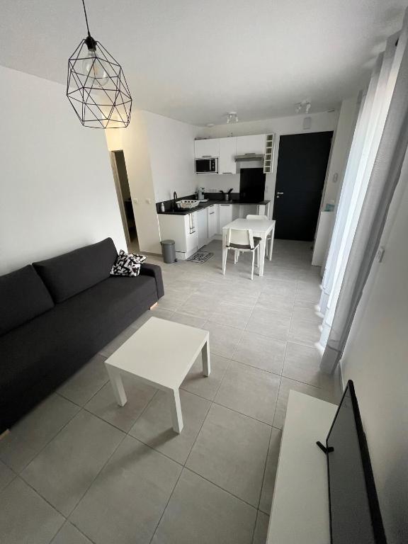 un salon avec un canapé et une table dans l'établissement Appartement neuf proche Prado/plages/calanques, à Marseille