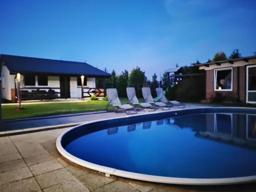 uma piscina com espreguiçadeiras ao lado de uma casa em Comfortable holiday homes, swimming pool, Rewal em Rewal