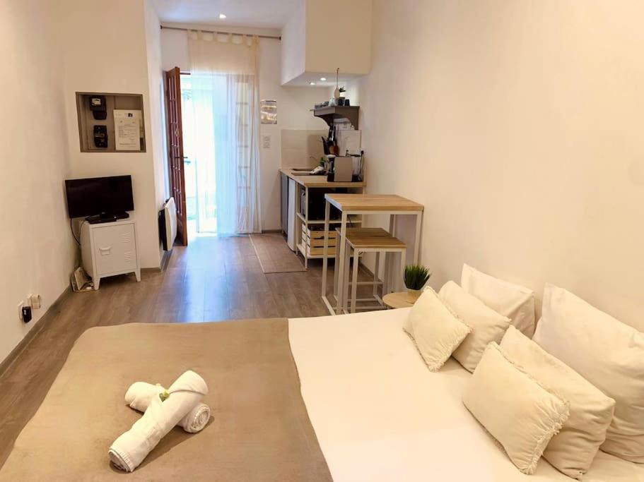 a bedroom with a large white bed with pillows at "Pascal 1" Eglise St Louis - Studio Cosy Quartier Haut in Sète