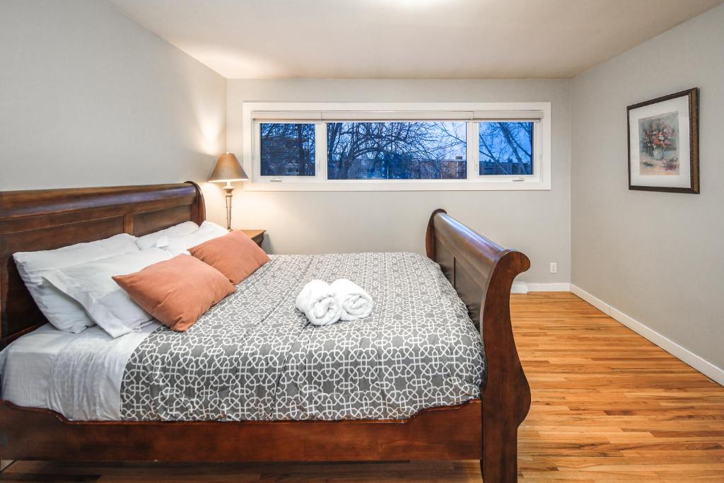 ein Schlafzimmer mit einem Holzbett und einem Fenster in der Unterkunft A-Home by chinook mall and Heritage park in Calgary