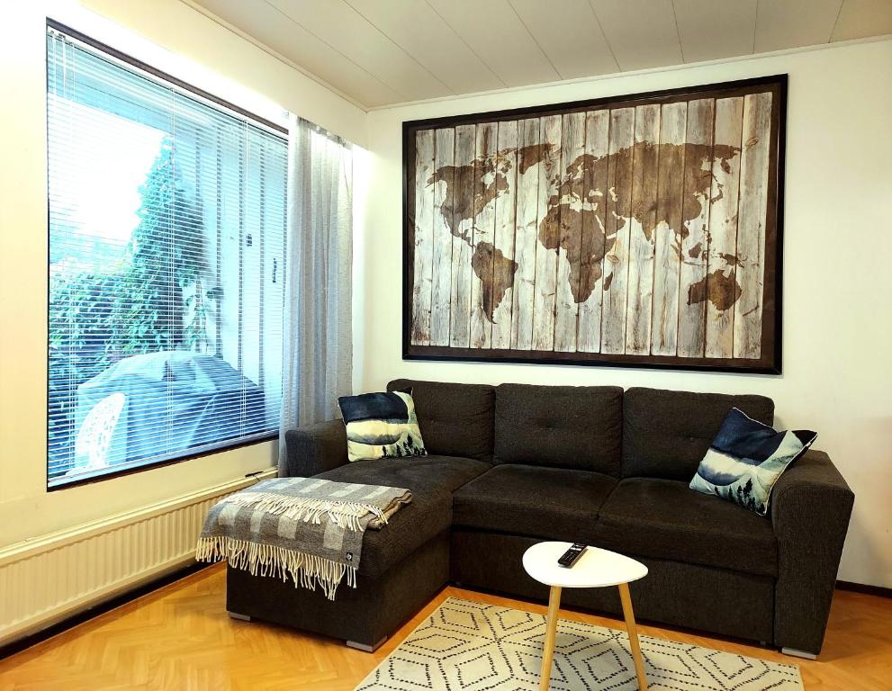 a living room with a brown couch and a window at Arantilan rivitalokaksio lähellä Nakkilan keskustaa in Nakkila