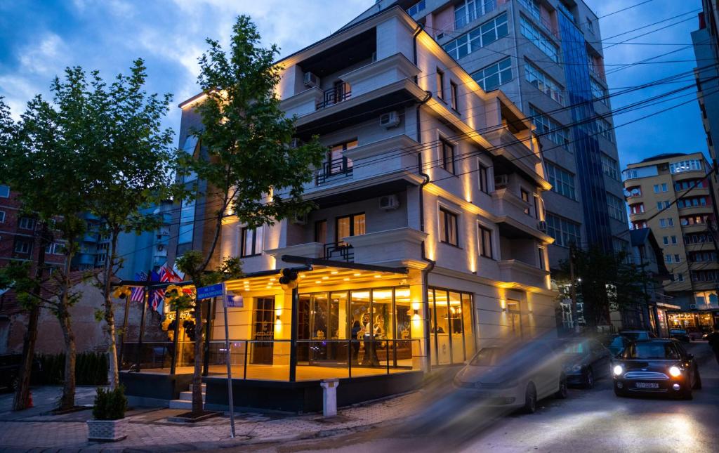 un edificio en una calle de la ciudad con coches pasando por él en Hotel City Star, en Pristina