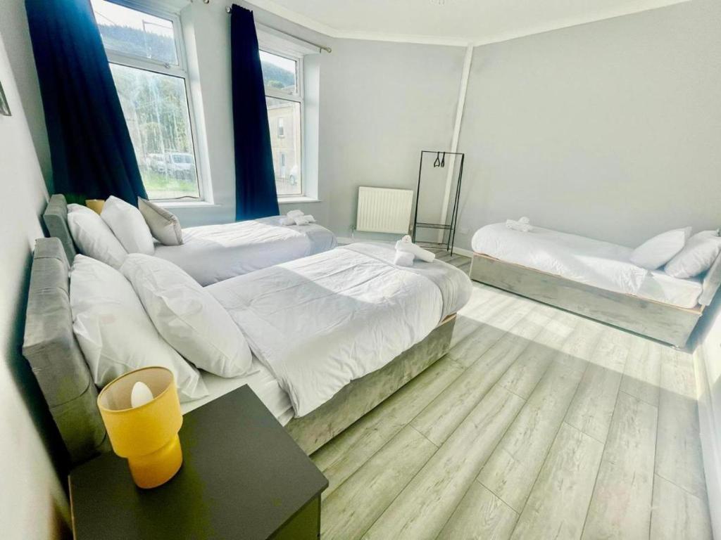 um quarto grande com 2 camas e uma mesa em Cozy Home Afan Valley Mountain Retreat - Sleeps -8 em Glyncorrwg