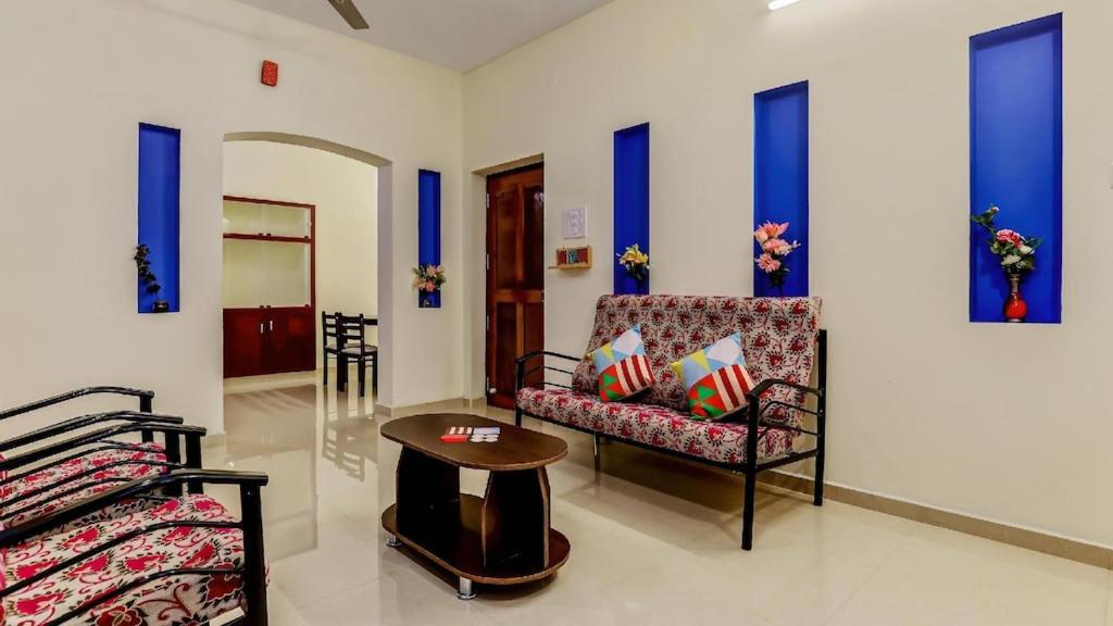 ein Wohnzimmer mit einem Stuhl und einem Tisch in der Unterkunft SHRI Sai Balavany Residency in Puducherry