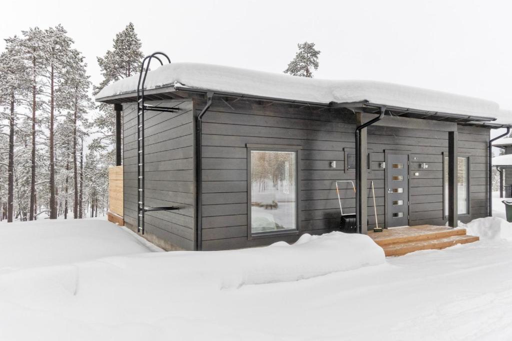 una pequeña cabaña en la nieve en el bosque en Villa Paadari Lusma, en Inari
