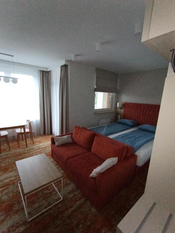 uma sala de estar com um sofá vermelho e uma cama em BelMare 427Aqua em Międzyzdroje