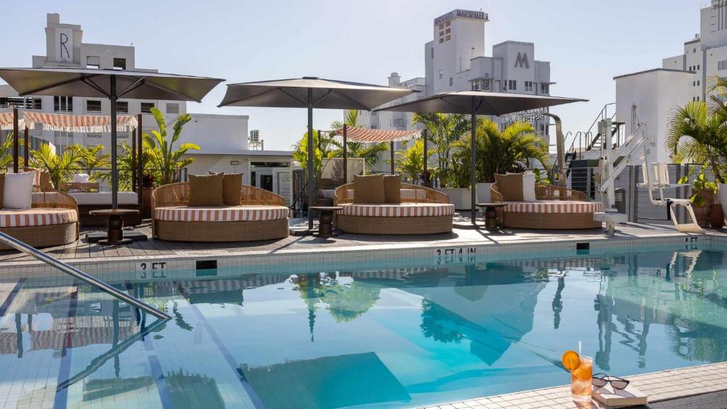 een zwembad in een hotel met stoelen en parasols bij Uma House by Yurbban South Beach in Miami Beach