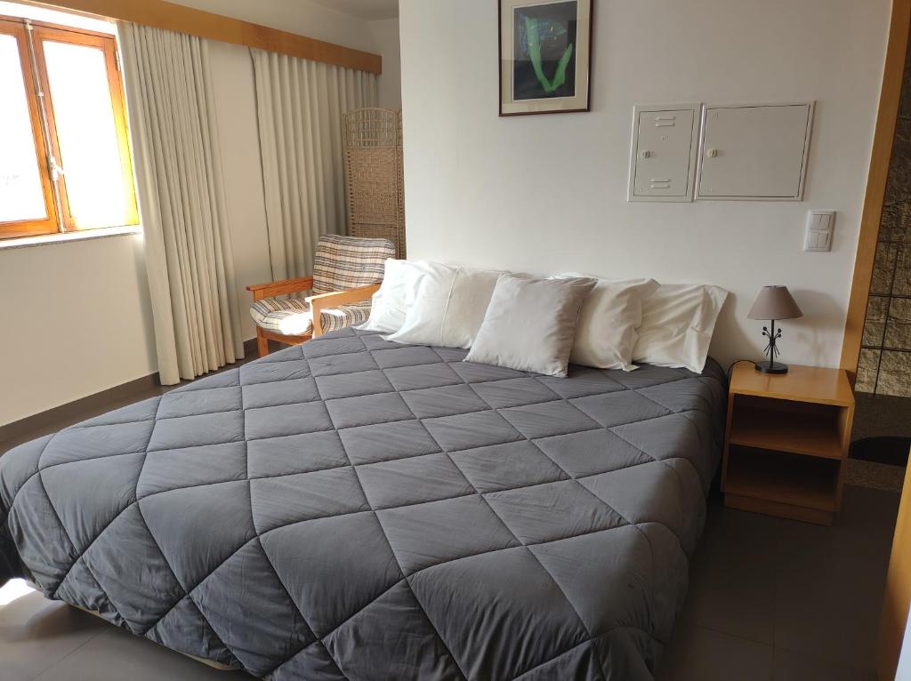 a bedroom with a large bed with a gray blanket at Valentim House in Viana do Castelo