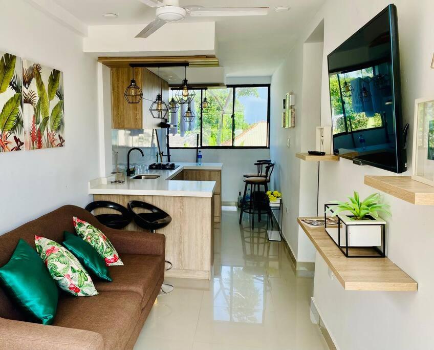 a living room with a couch and a kitchen at Hermoso apartamento céntrico in Mompos