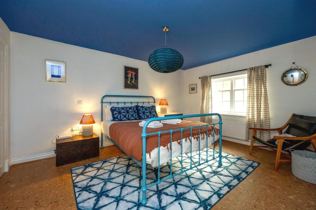 ein Schlafzimmer mit einem Bett und einer blauen Decke in der Unterkunft Beautiful Boho House in Kemptown in Brighton & Hove