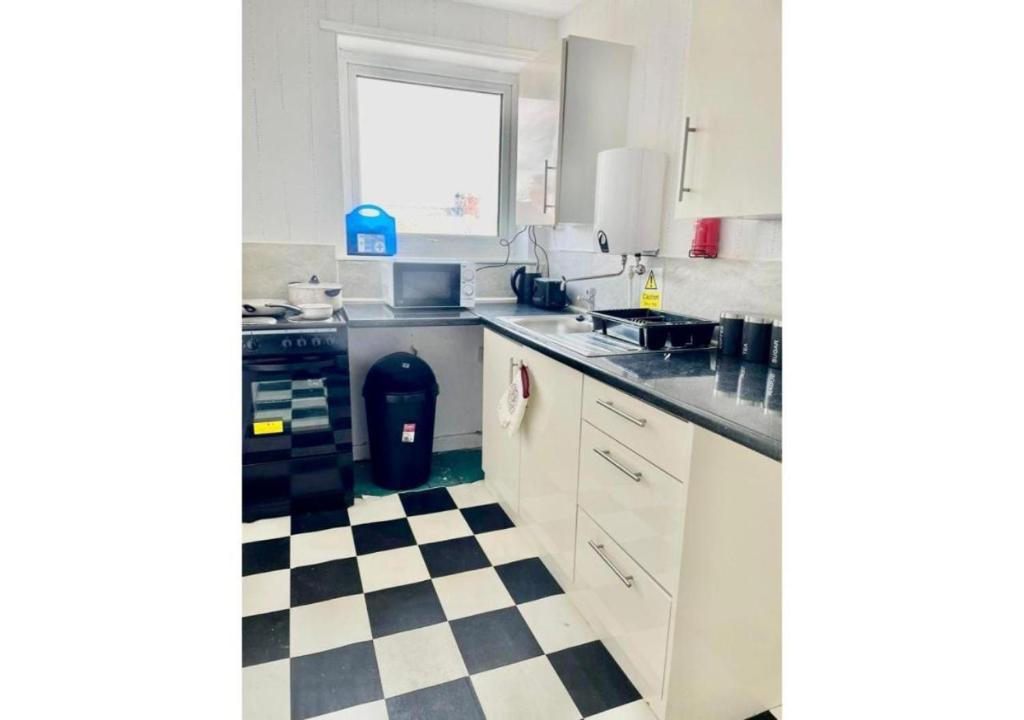 a kitchen with a black and white checkered floor at Pleasant 1 Bed Budget Apartment Near Blackpool City Centre 4 in Blackpool