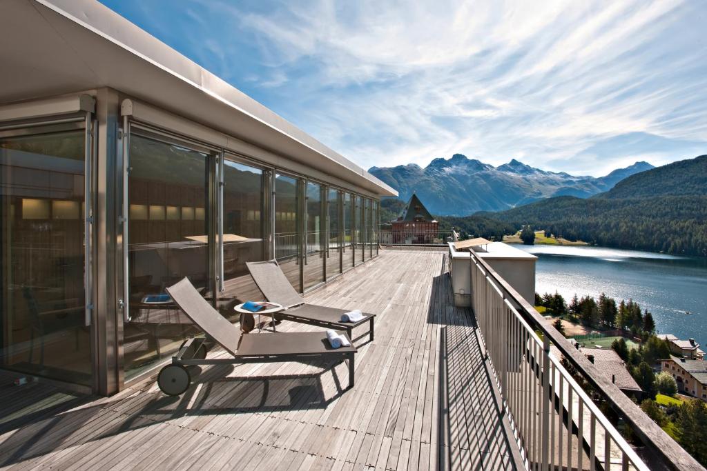 a balcony of a house with a view of a lake at Hotel Schweizerhof St. Moritz in St. Moritz