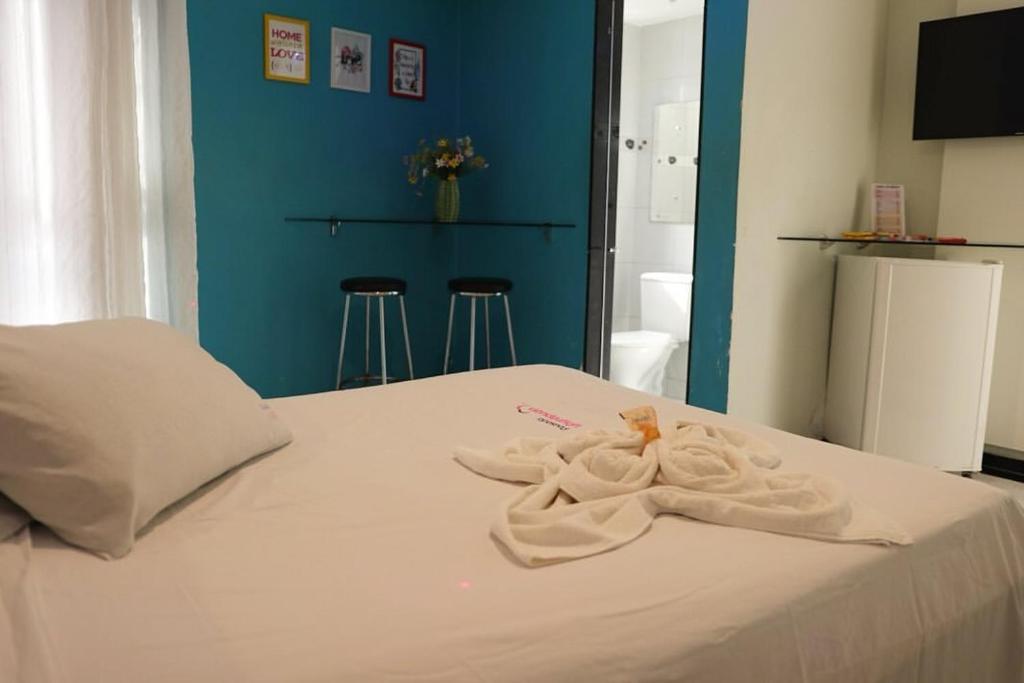 a bedroom with a bed with two towels on it at Pousada Ybyrápuan in Campina Grande
