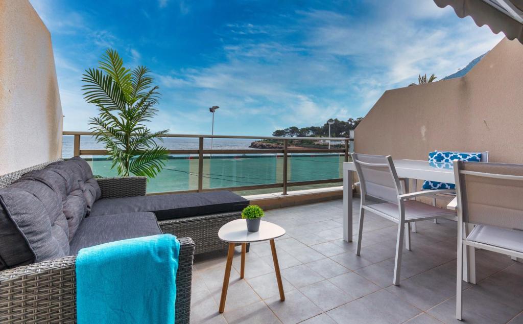salon z kanapą i stołem na balkonie w obiekcie Apartamento Frentemar 1 by Costa CarpeDiem w mieście Calpe