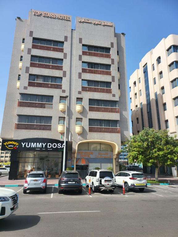 a parking lot with cars parked in front of a building at Top Stars Hotel in Abu Dhabi