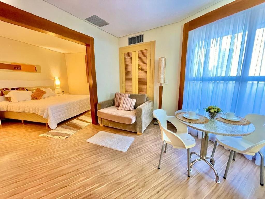 um quarto com uma cama, uma mesa e uma cadeira em 102 · Apto no batel c/ Ar condicionado em Curitiba