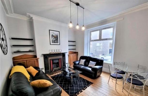 a living room with a couch and a fireplace at Howburn Place in Aberdeen