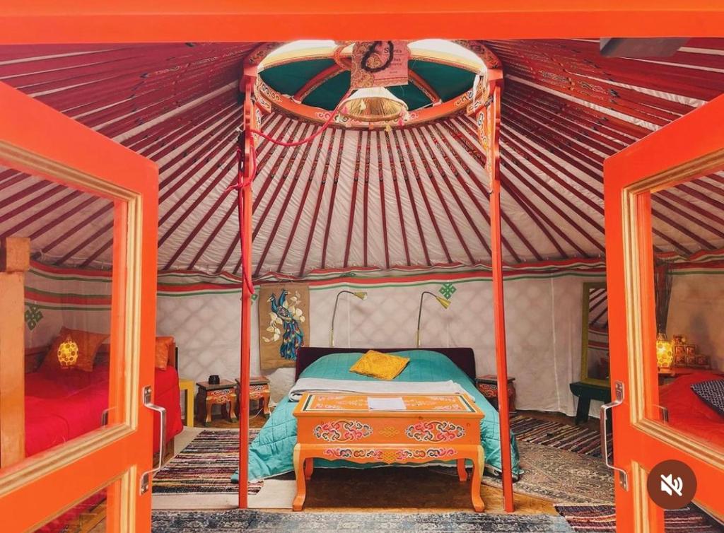 ein Schlafzimmer mit einem Bett in einem Zelt in der Unterkunft Anouchka Ô fil 2 l'eau, yourte en bord de Lac in Saint-Jean-Saint-Maurice-sur-Loire