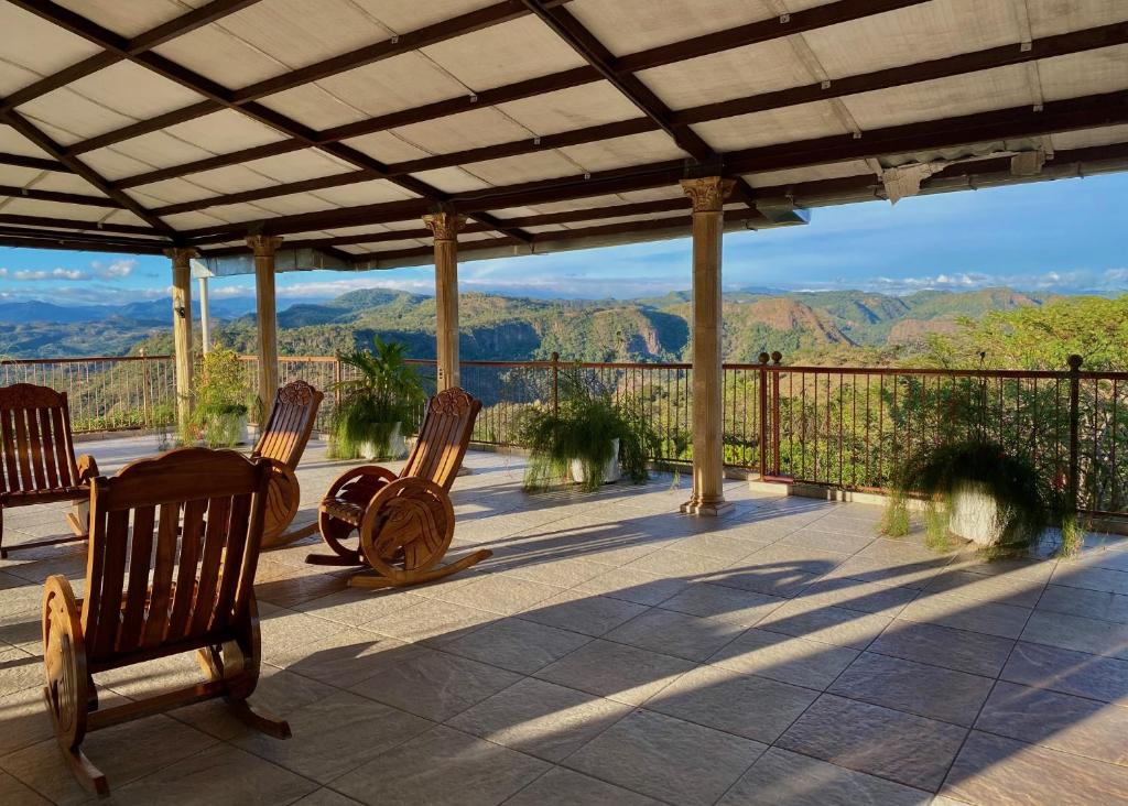 a porch with chairs and a view of mountains at Hotel y Restaurante La Perla, Cacaopera, Morazan, El Salvador in Cacaopera