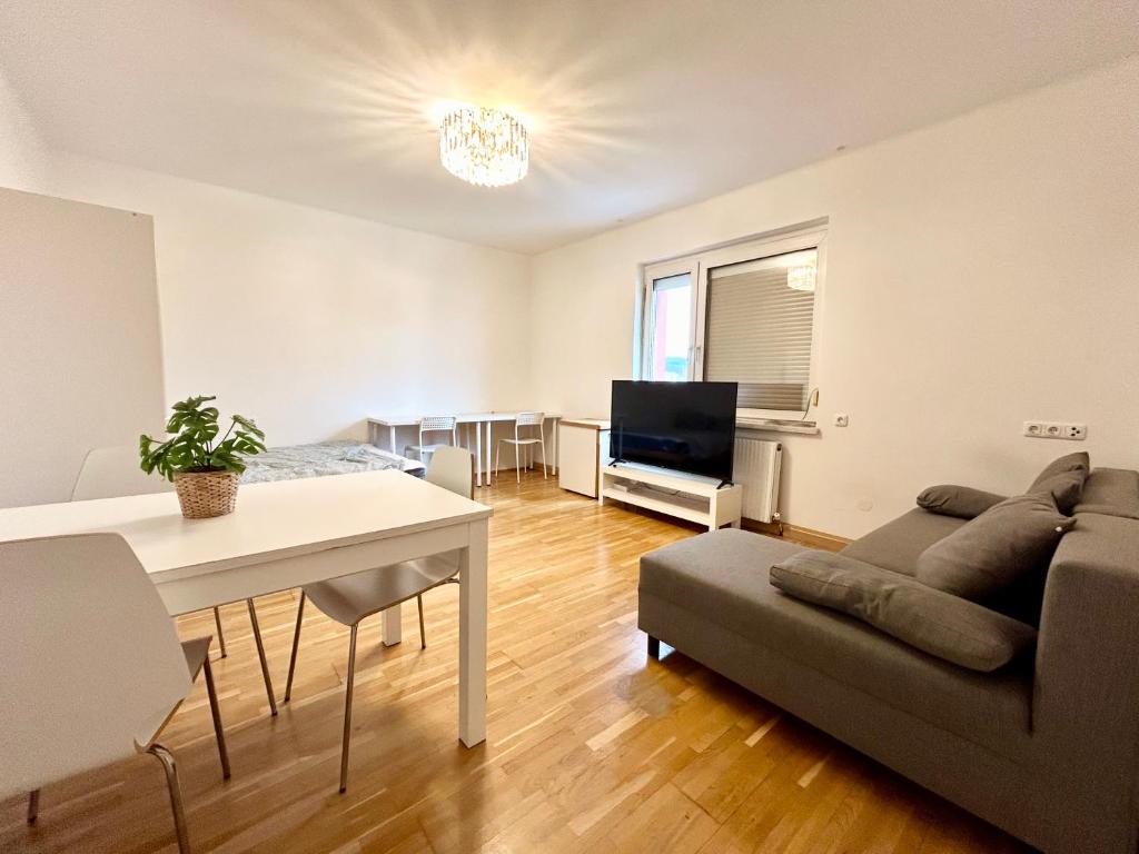 a living room with a couch and a table at StayRoom Apartments I Haven im Zentrum von Linz in Linz