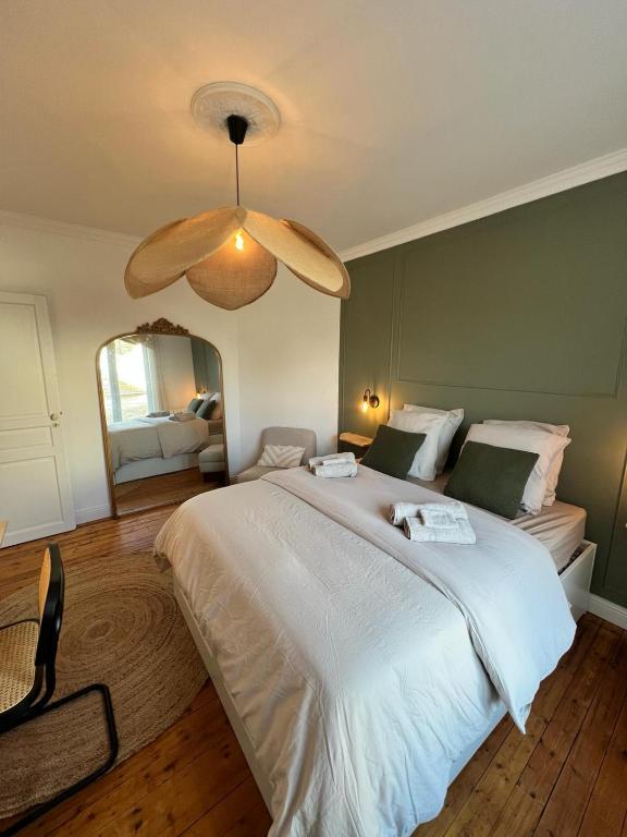 une chambre avec un grand lit blanc et un miroir dans l'établissement Grand Cerf - Centre historique, à Reims