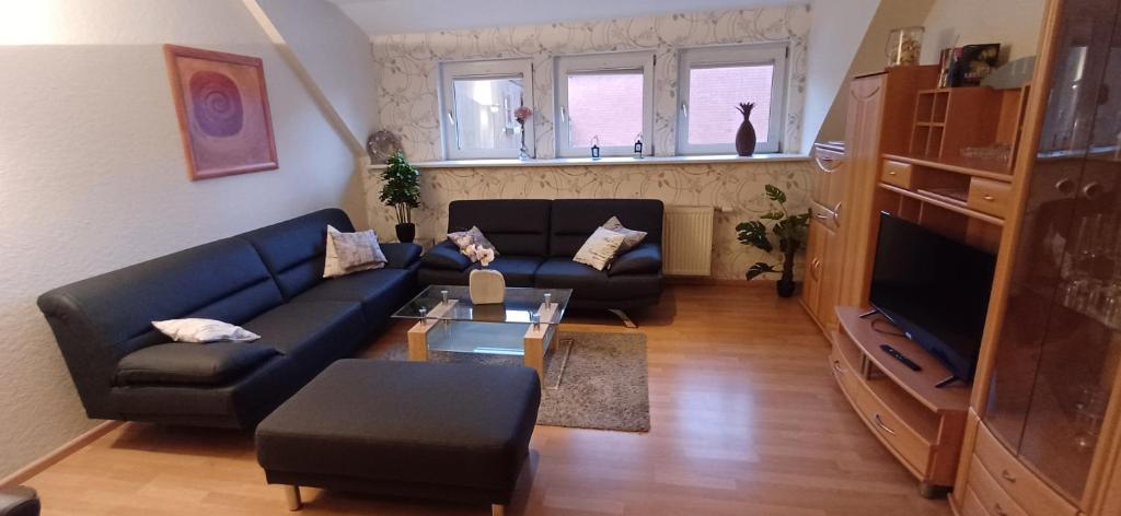 a living room with a blue couch and a table at Meine Ferienwohnung Seeburg 1 in Seeburg