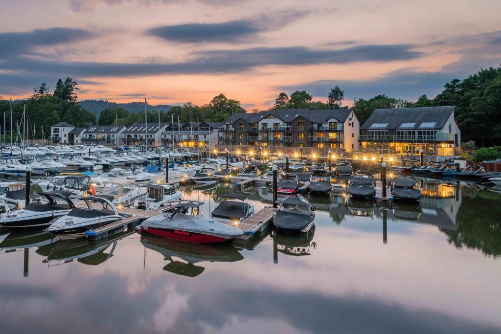 a group of boats docked in a marina at night at Lakeland Apartment At Windermere Marina Village in Bowness-on-Windermere