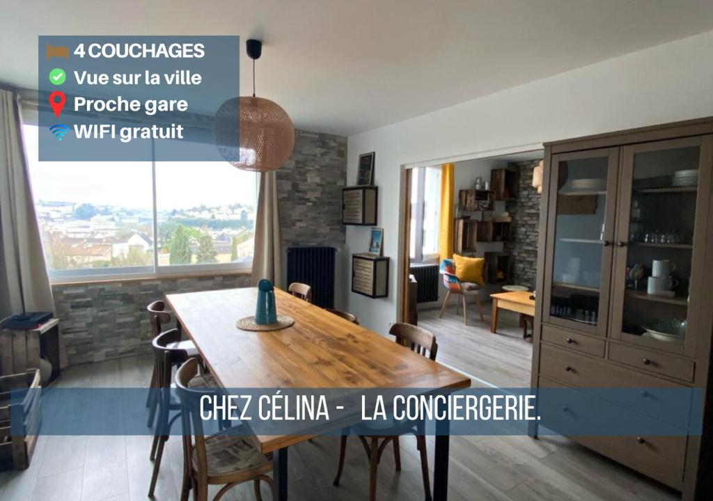 ein Esszimmer mit einem Holztisch in einem Zimmer in der Unterkunft Chez Célina - La Conciergerie. in Buxerolles