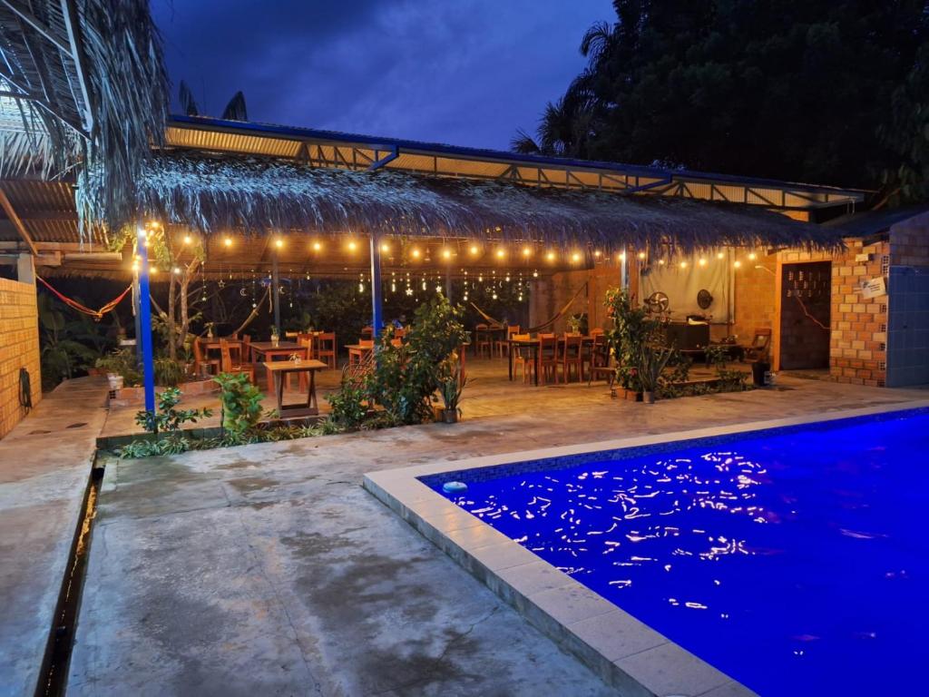 una casa con piscina por la noche en Alojamiento, Restaurante Chic Paradise, en Iquitos