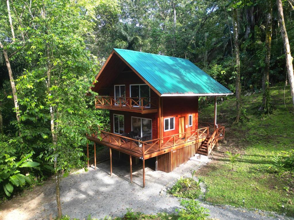 a cabin in the woods with a green roof at Gaia Nature Lodges at Bluff Beach in Bocas del Toro