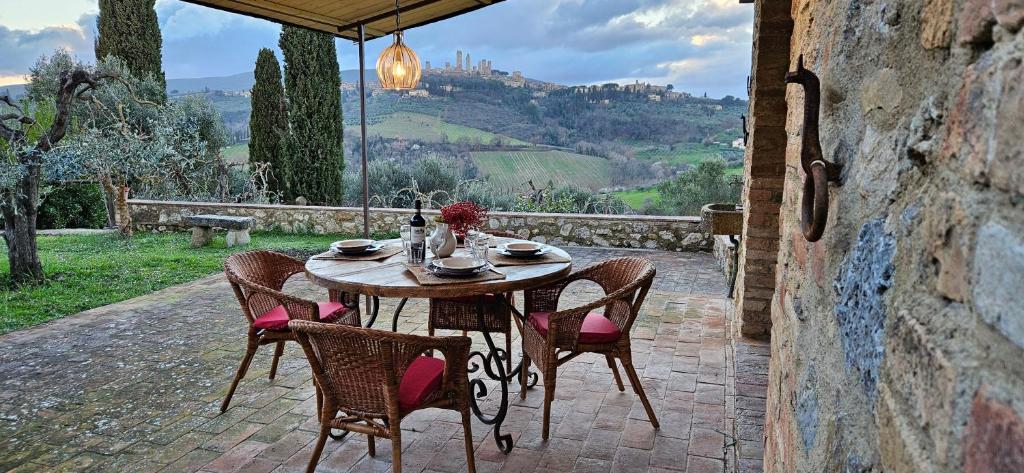een tafel en stoelen op een patio bij Casale Esclusivo con Piscina e Vista su San Gimignano in San Gimignano