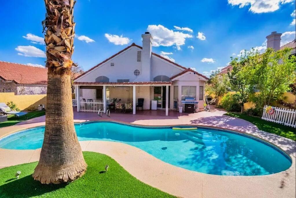 a palm tree in front of a house with a swimming pool at Pet Friendly Rancher with Pool/SW Las Vegas in Las Vegas