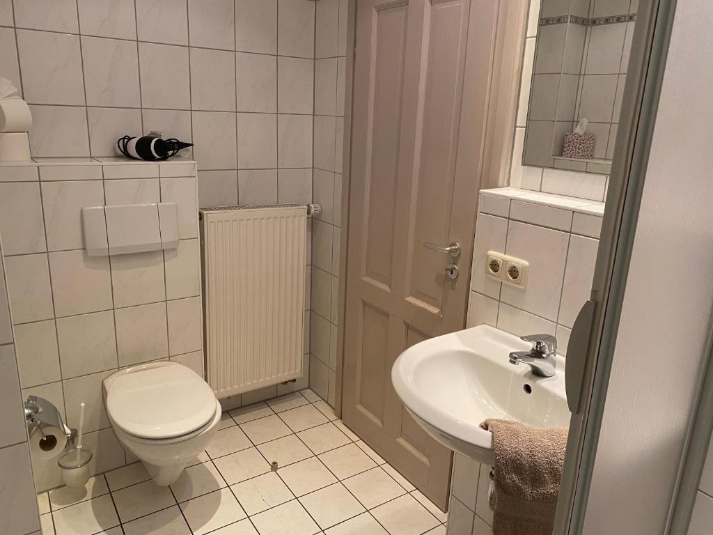 a small bathroom with a toilet and a sink at Hotel Weinstube am Markt in Gerolzhofen