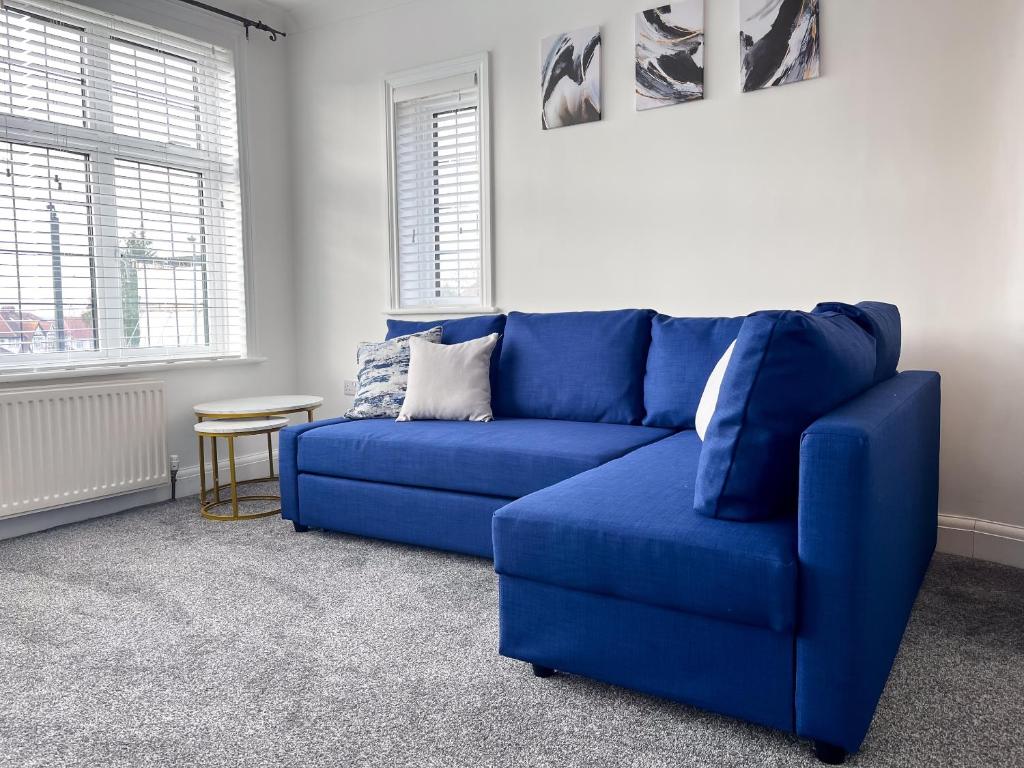 a blue couch in a living room with a table at Wembley Stadium Central Modern & Cozy Apartment in London