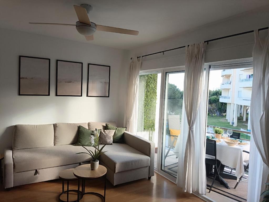 ein Wohnzimmer mit einem Sofa und einem Tisch in der Unterkunft Soleado y luminoso a 3 minutos de la playa-Carihuela in Torremolinos