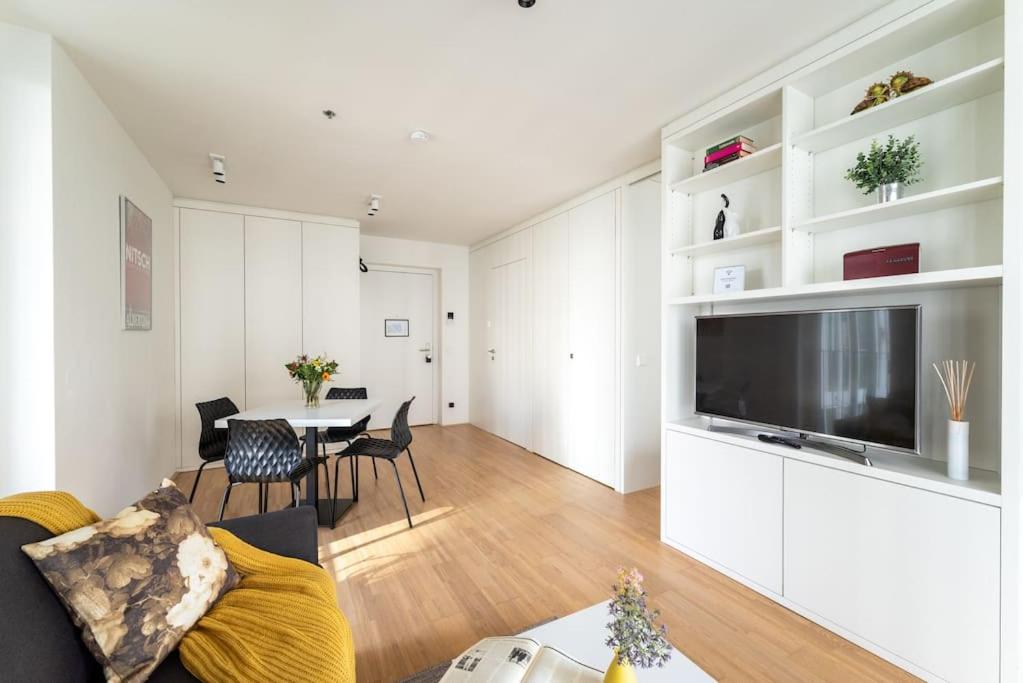 een woonkamer met een grote televisie en een tafel bij HM • Smart Studio with Terrace in Wenen