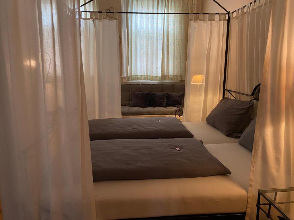 a bedroom with two beds and a canopy bed at Hotel Weinstube am Markt in Gerolzhofen