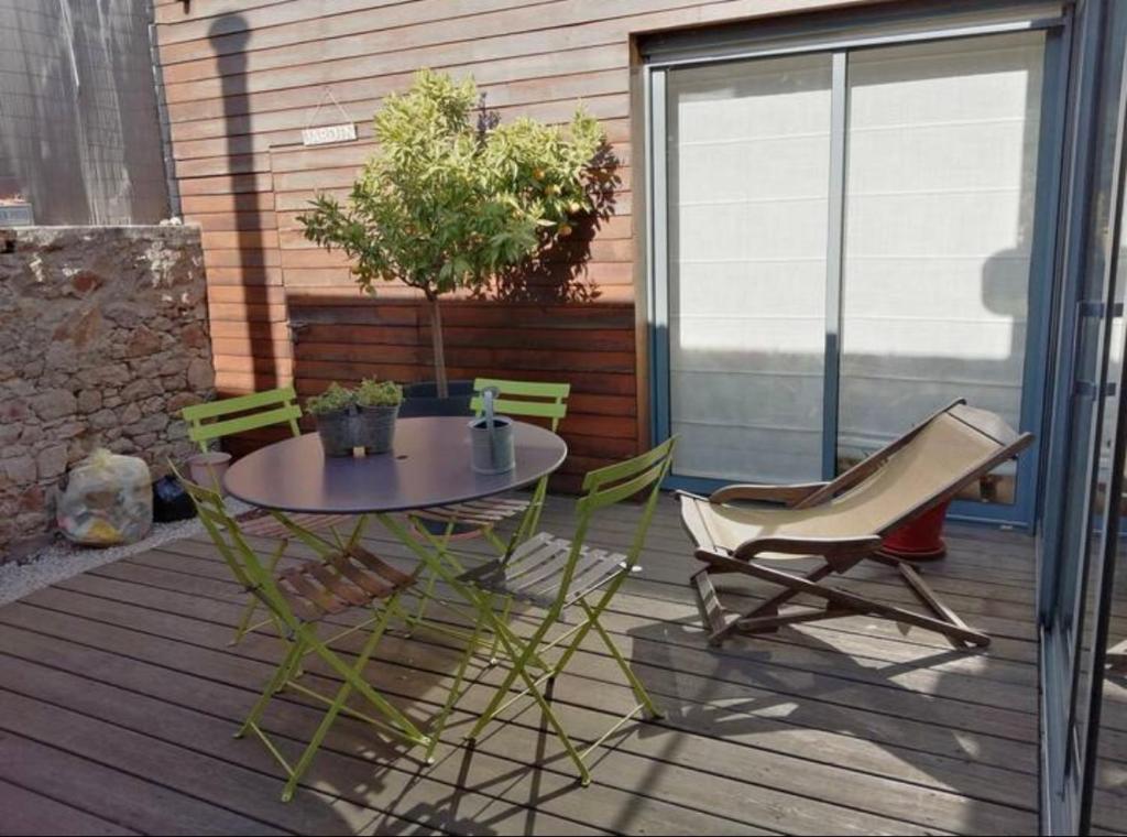 einen Tisch und Stühle auf einer Terrasse mit Tisch und Stühlen in der Unterkunft Chambre et salle d'eau privées dans maison de ville in La Roche-sur-Yon